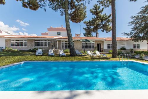 a swimming pool in front of a house at Villa Maia in Corroios