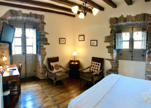 a bedroom with a bed and chairs in a room at Casa Rural Zigako Etxezuria in Ziga