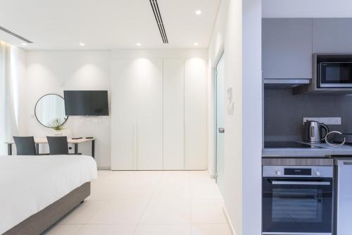 a kitchen and a bedroom with a bed and a table at NAPA GEM SUITES by LUXEL VILLAS in Ayia Napa