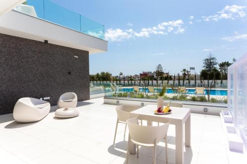 an image of a balcony with a table and chairs at NAPA GEM SUITES by LUXEL VILLAS in Ayia Napa
