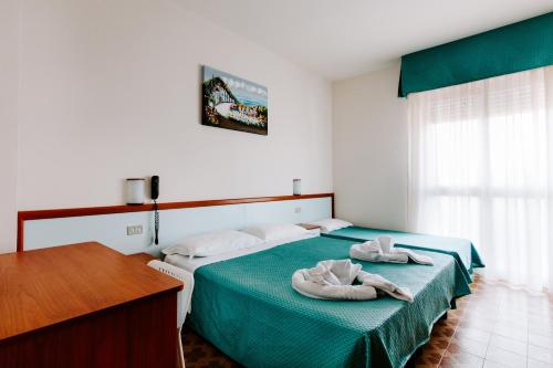 two towels on a bed in a room at Hotel Villa Claudia in Bellaria-Igea Marina