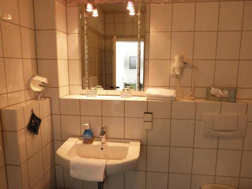 a bathroom with a sink and a mirror at Hotel Jägerhof in Mayen