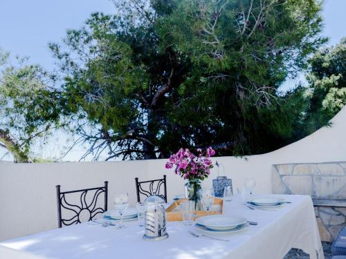 una mesa con un mantel blanco y un jarrón de flores en Holiday Home La Yaya by Interhome, en Fanadix