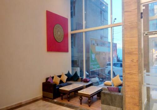 a living room with a couch and tables and a window at Clarks Inn Suites Katra in Katra