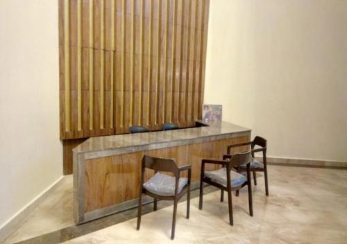 a table and chairs in a room with a wall at Clarks Inn Suites Katra in Katra