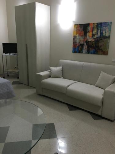uma sala de estar com um sofá e uma mesa de vidro em B&B Aliga em Porto Empedocle