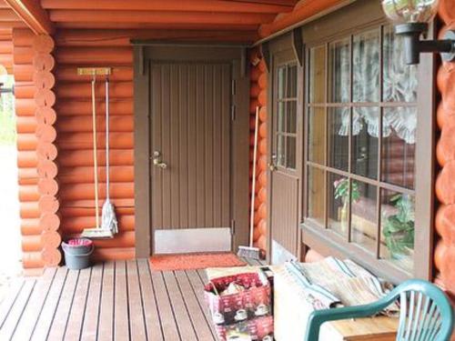 a porch of a cabin with a bench and a door at Holiday Home 6012 by Interhome in Suninsalmi