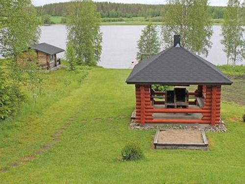 a gazebo in the grass next to a lake at Holiday Home 6012 by Interhome in Suninsalmi