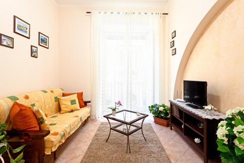 a living room with a couch and a tv at Doris House Sorrento in Sorrento