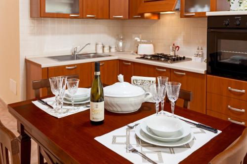 a kitchen with a table with a bottle of wine and glasses at Doris House Sorrento in Sorrento