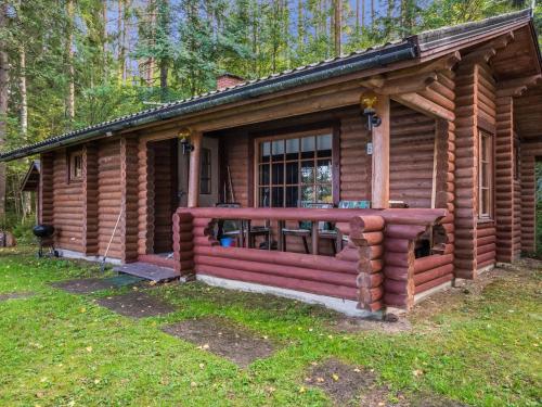 a log cabin in the woods with a porch at Holiday Home Länsiranta by Interhome in Hirvikoski