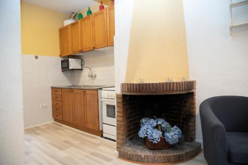 a kitchen with a brick fireplace in a room at Holiday home Can Clerc in Osor