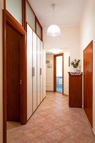 a hallway with wooden doors and a tile floor at Doris House Sorrento in Sorrento