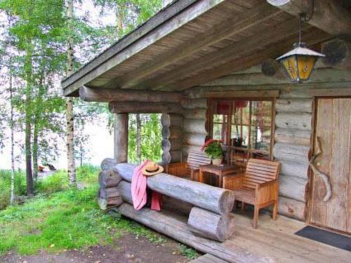 a log cabin with a couch in front of a table at Holiday Home Mäkitorppa by Interhome in Pätiälä
