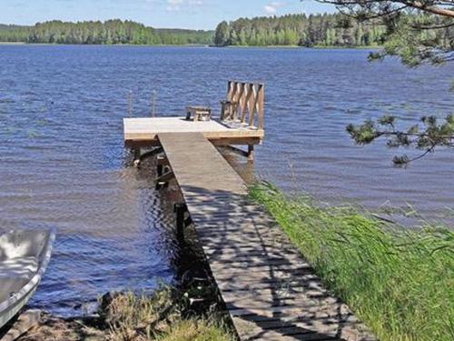 a dock on a lake with a table and chairs at Holiday Home Mäkitorppa by Interhome in Pätiälä