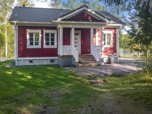 una pequeña casa roja con patio en Holiday Home Villa urho by Interhome, en Löytö