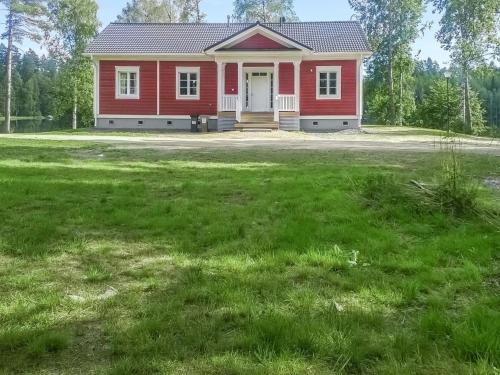 una casa roja con un gran césped delante de ella en Holiday Home Villa elisabet by Interhome, en Löytö