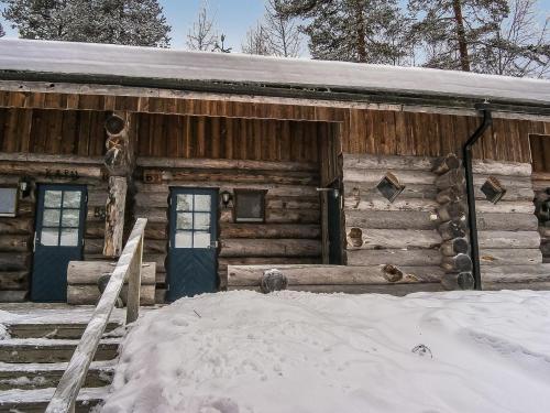 a log cabin with snow in front of it at Holiday Home Vuokatinportti b 9 by Interhome in Lahdenperä