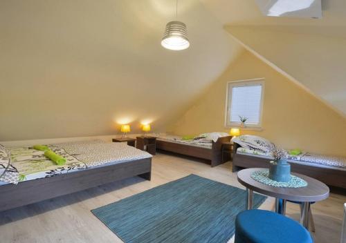 a large room with two beds and a table at Domki Spokojny Zakątek z balią z jacuzzi in Lipowa