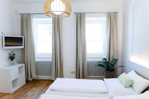 a white room with a bed and two windows at Vino Verde in Poysdorf