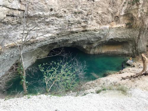 a cave in the side of a mountain with green water at Face West Le Pontet in Le Pontet