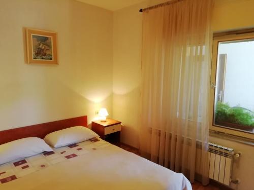 sypialnia z 2 łóżkami i oknem w obiekcie Apartments Jadranka Ivana Pula w Puli