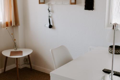 a white room with a table and a white chair at Hotel Sandvig Havn in Sandvig