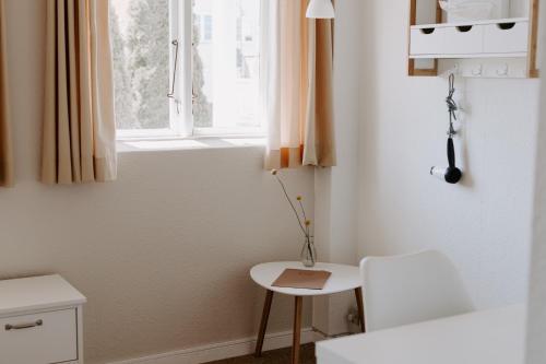 a small room with a table and a window at Hotel Sandvig Havn in Sandvig