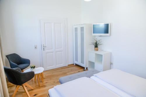 ein Schlafzimmer mit einem Bett, einem Stuhl und einem TV in der Unterkunft Vino Verde in Poysdorf