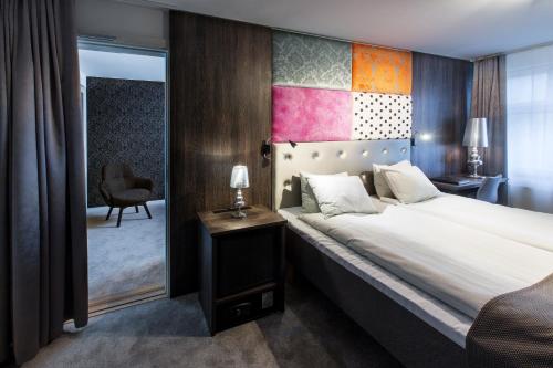 um quarto com uma cama grande e uma cadeira em City Hotel Örebro em Örebro