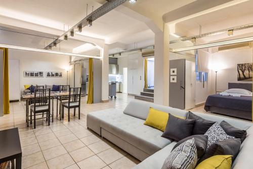 a living room with a couch and a dining room at Renovated Loft At the Center of Monastiraki in Athens