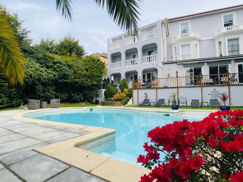 a swimming pool in front of a large building at Glenorleigh in Torquay