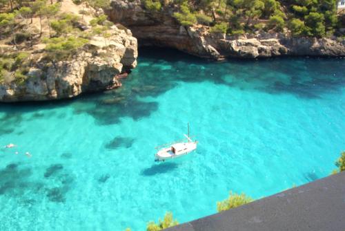 a boat in a body of water with rocks at Finca Agroturismo Sa Cova den Borino in Campos