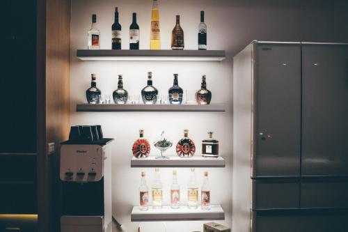 a display of bottles of alcohol on shelves on a wall at Lounge away in Taitung City