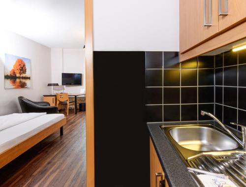 a kitchen with a sink and a bed in a room at historic Apart in Erlangen