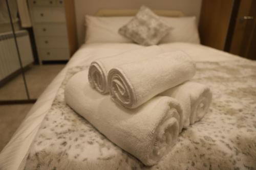 a pile of towels sitting on top of a bed at South Shield's Hidden Gem Emerald Apartment sleeps 6 Guests in South Shields