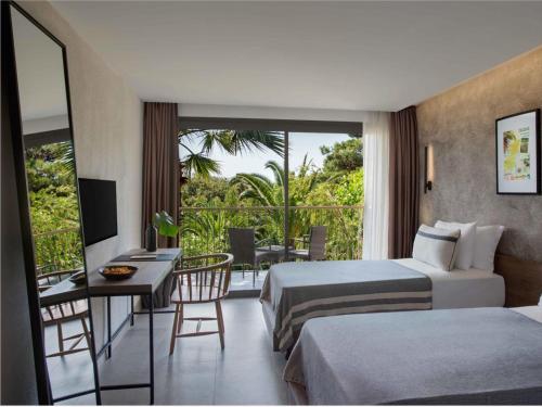 een hotelkamer met 2 bedden, een bureau en een balkon bij Club Marvy in Ozdere