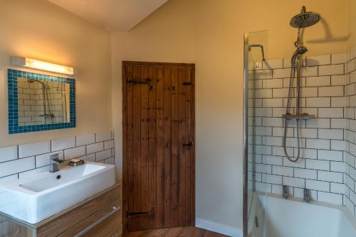 ein Badezimmer mit Waschbecken, Badewanne und Dusche in der Unterkunft Bramley Cottage in Ottery Saint Mary