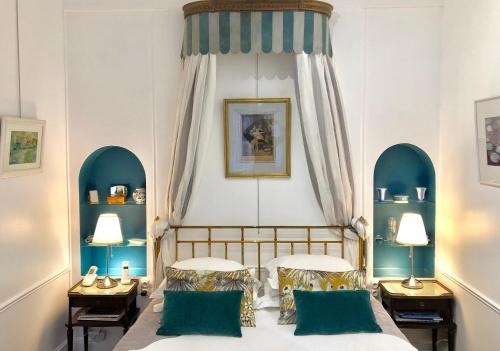 een slaapkamer met 2 bedden en 2 tafels en 2 lampen bij VILLA la GLORIETTE in Rouen