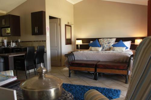 a bedroom with a bed with blue pillows on it at Drakensview Self Catering in Winterton