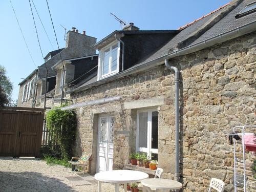 une maison en pierre avec une table et des chaises devant elle dans l'établissement maison de pécheur typique presqu’île Saint Jacut Sur Mer, à Saint-Jacut-de-la-Mer