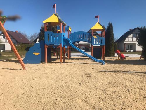 a playground with a slide in the sand at Morska Kraina in Białogóra