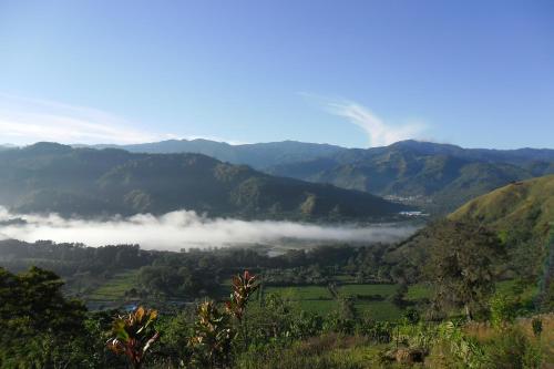 a view of a valley with fog in the mountains at Rinconcito Verde in Ujarrás