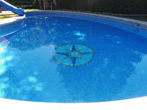 a large blue swimming pool with a sign in it at Casa Cantábrico in Castro-Urdiales