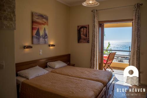 1 dormitorio con 2 camas y ventana con vistas en Blue Heaven Apartments, en Agios Georgios Pagon