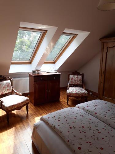 a bedroom with skylights and a bed and two chairs at Adalbert Ház in Budapest