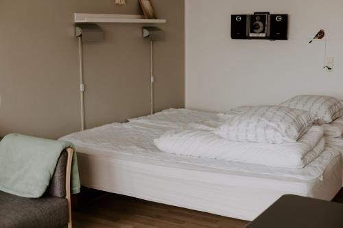 a bed in a room with a camera on the wall at Hotel Sandvig Havn in Sandvig