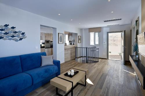 a living room with a blue couch and a table at Seascape Luxury Residences in Agia Pelagia