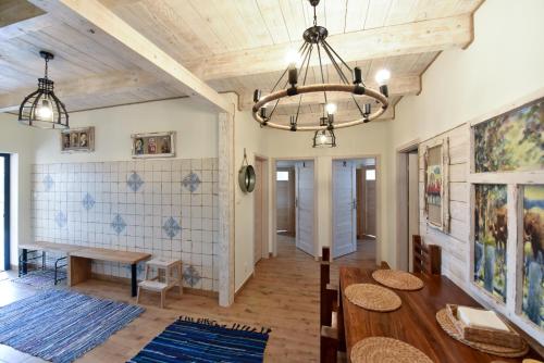 a dining room with a table and a chandelier at Babushka Noclegi in Białowieża