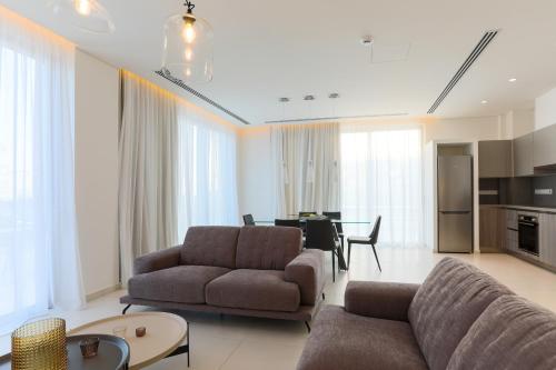 a living room with two couches and a dining room at NAPA GEM SUITES by LUXEL VILLAS in Ayia Napa
